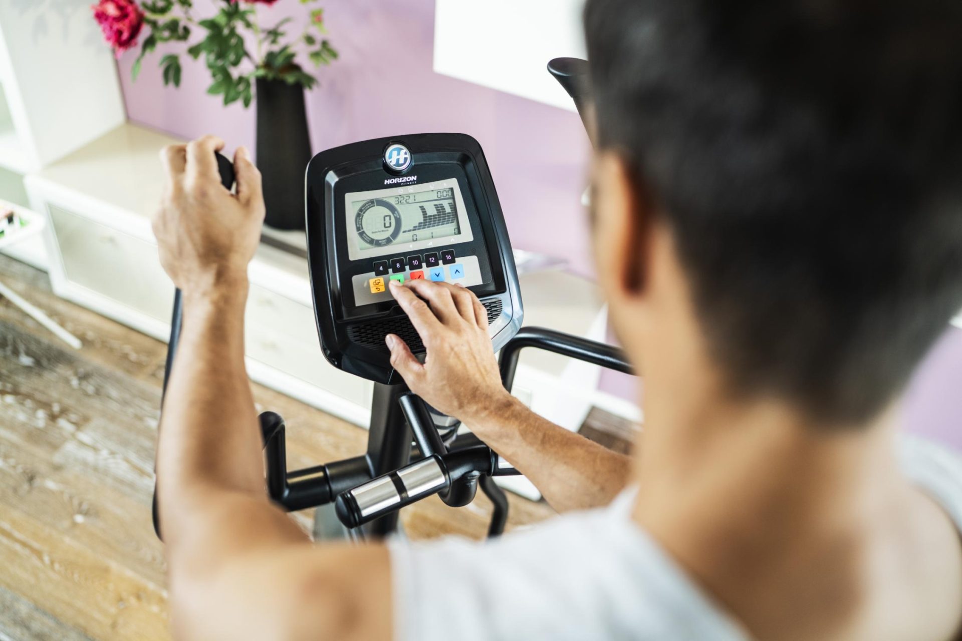 Mann mit Display auf Fitnessgerät