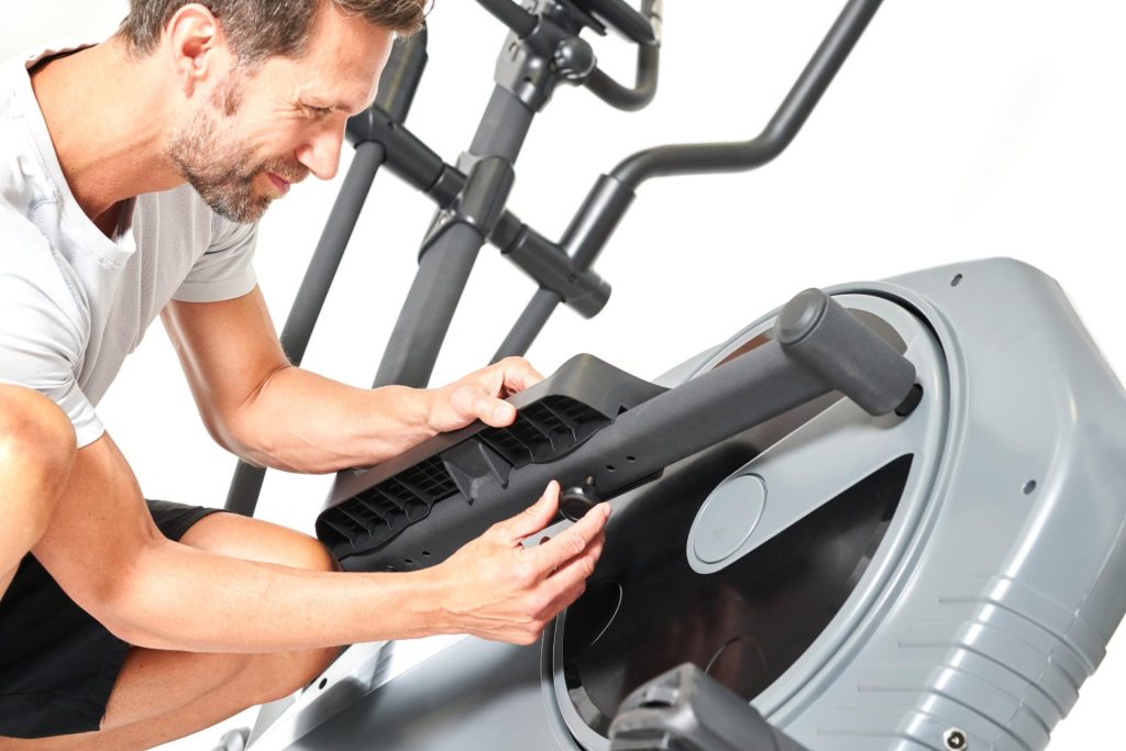 Mann repariert Crosstrainer