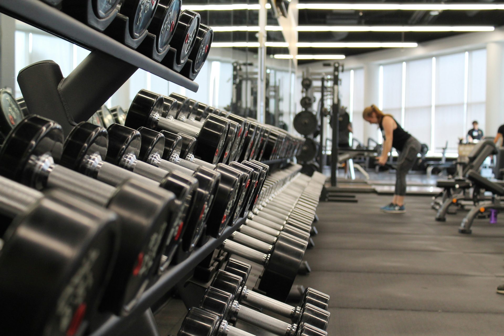 Frau in Fitnessstudio mit Hanteln